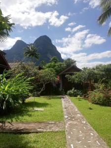 um caminho que leva a uma casa com montanhas ao fundo em Lattanavongsa guesthouse and Bungalows em Ban Ngoy-Nua