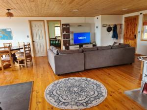 sala de estar con sofá y TV en Cabaña 3D 1B, Curaco de Velez, en Curaco de Velez