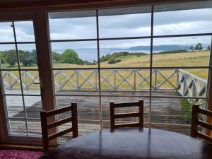 a table and two chairs in a room with a window at Cabaña 3D 1B, Curaco de Velez in Curaco de Velez