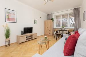 Televízia a/alebo spoločenská miestnosť v ubytovaní Białe Aleje Mokotów Apartment Metro by Noclegi Renters