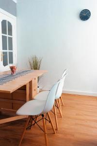 een eetkamer met een tafel en witte stoelen bij Triana Apartment in Sevilla
