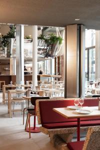 a restaurant with tables and chairs and windows at Pilo Lyon in Lyon