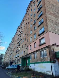 a large brick building with windows on a street at Слава Героям 11 Сеть апартаментов Alex Apartments Бесконтактное заселение 24-7 in Poltava