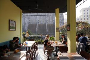 河内Drift Backpackers Hostel的一群人坐在餐厅的桌子旁