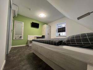 ein großes Bett in einem Zimmer mit grünen Wänden in der Unterkunft Pension Am Stadtrand Zerbst in Zerbst