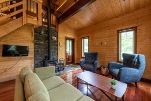 a living room with a couch and chairs and a fireplace at The Qu INN - Cozy Cabin in Parson
