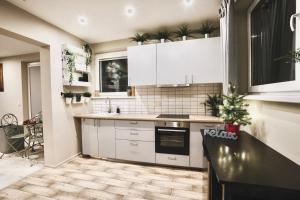 a kitchen with white cabinets and a black counter top at Baltamiškio slėnis in Baltamiškis