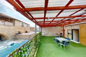 a patio with a table and chairs in a building at The house in the Ramchal in Acre