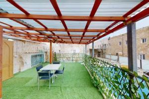 a roof garden with a table and chairs on a balcony at The house in the Ramchal in Acre