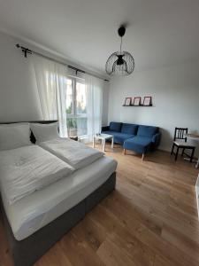 a bedroom with a large bed and a blue couch at BAST Apartamenty Ptak Szpital Matki Polki Mandoria Orientarium Atlas Arena Plac Zabaw - Zamojska 20a m16 Parking bezpłatny STACJA KOLEJOWA 100m in Łódź