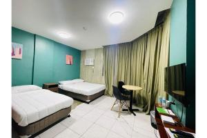 a hotel room with two beds and a television at OYO 925 Rcee Place in Cebu City