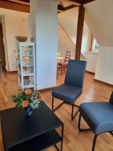a living room with two chairs and a table with flowers at cosy home in Dresden