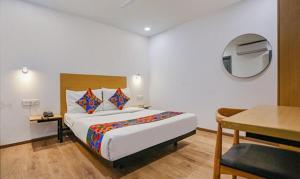 um quarto com uma cama, uma mesa e uma secretária em FabHotel Indraprastha - Shahdara em Nova Deli