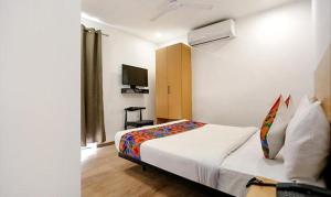 um quarto com uma cama e uma televisão em FabHotel Indraprastha - Shahdara em Nova Deli