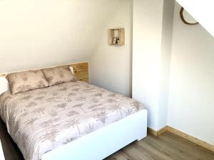 a small bedroom with a bed in the corner at Cosy beach house for ocean & nature lovers in Noordwijk