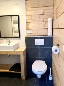 een badkamer met een wit toilet en een wastafel bij Cosy beach house for ocean & nature lovers in Noordwijk
