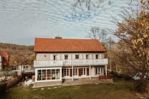 a large white house with an orange roof at Waldchalet Am Steinberg FEWO in Wernigerode