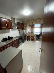 a kitchen and dining room with a table in it at Alojamento Amor de Mãe in São Teotónio