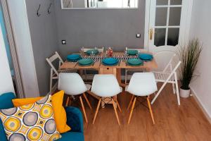 een eetkamer met een houten tafel en witte stoelen bij Triana Apartment in Sevilla