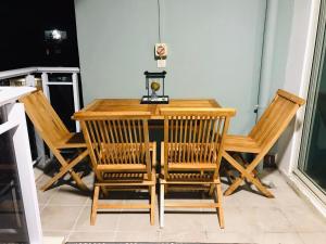 una mesa de madera con sillas y una lámpara. en Mave Mai Studio Papeete, en Papeete