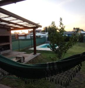 una hamaca en un patio junto a una piscina en Casa con pileta en Funes en Funes