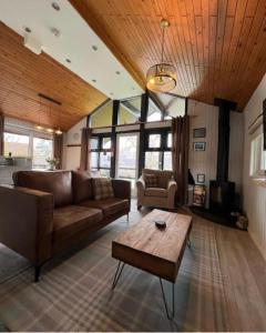 uma sala de estar com um sofá e uma mesa de centro em Bell Rock Holiday Lodge em Killin