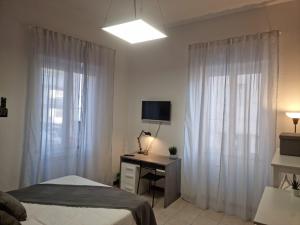 1 dormitorio con 1 cama y escritorio con ordenador en Laura Four, en Messina