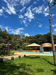 a swimming pool with a gazebo in a park at Aconchego da bocaina in Cunha