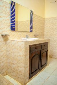 ein Bad mit einem Waschbecken und einem Spiegel in der Unterkunft LOTUS HOTEL in Diego Suarez