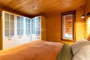 a bedroom with a bed in a wooden room at The Qu INN - Cozy Cabin in Parson