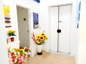 een hal met een vaas met bloemen naast een deur bij B&B Family - Affitta camere in Reggio di Calabria