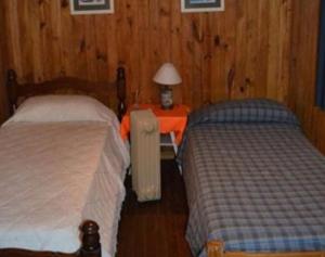 ein Schlafzimmer mit zwei Betten und einem Tisch mit Lampe in der Unterkunft La Caleta in Tigre