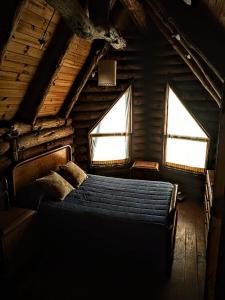 a bedroom with a bed in a log cabin at Malo Watson Hostel in Tandil