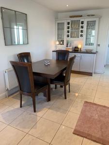 a dining room with a wooden table and chairs at Home On The Edge Of Ireland! in Belmullet