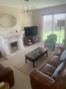 a living room with a couch and a coffee table at Home On The Edge Of Ireland! in Belmullet