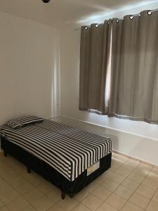 a bed sitting in a room with a window at Martin Quintanilha 1B in Goiânia