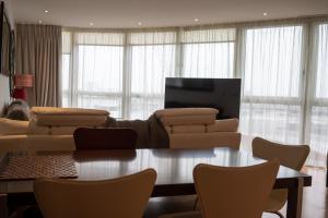 a living room with a couch and a table and chairs at Luxury 3 Bedroom 3 Bathroom Balcony Apartment - Gunwharf Quays Apartments in Portsmouth
