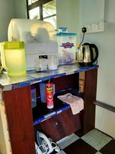 a kitchen with a shelf with food items on it at Penginapan MyCJ - Roomstay in Kuala Terengganu