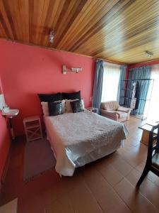 um quarto com uma cama e uma parede vermelha em Lion Rock View Guesthouse em Maseru