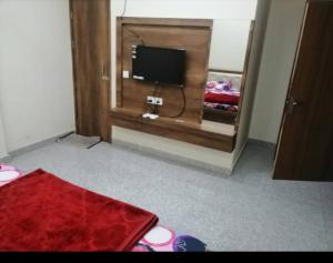 a room with a tv and a mirror in a bedroom at Anant Royal in Govardhan