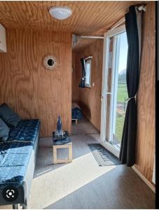 een kleine kamer met een bed en een glazen schuifdeur bij Logement insolite au cœur de l'Auvergne in Rochefort-Montagne