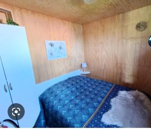 1 dormitorio con 1 cama en una habitación con paredes de madera en Logement insolite au cœur de l'Auvergne en Rochefort-Montagne