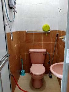 bagno con servizi igienici rosa e lavandino di Penginapan MyCJ - Roomstay a Kuala Terengganu