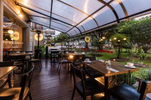 un restaurante con mesas y sillas de madera y techo de cristal en Hotel Morrison Zona Rosa en Bogotá