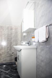 a white bathroom with a sink and a mirror at Motel Aura in Višegrad