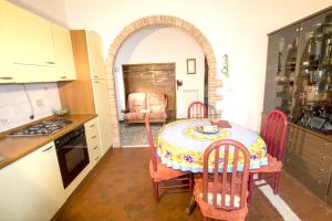 a kitchen with a table and chairs in a kitchen at 2 bedrooms apartement with shared pool and wifi at Massa Marittima in Massa Marittima