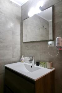 La salle de bains est pourvue d'un lavabo blanc et d'un miroir. dans l'établissement GK Ermou Str, à Athènes