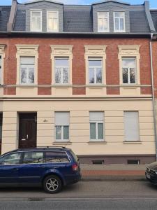 a blue car parked in front of a building at Apartament Suite 2 in Bernburg