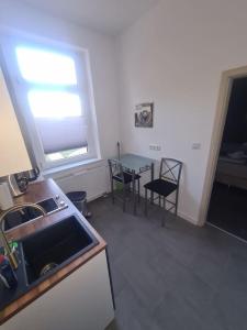 a kitchen with a sink and a table and a window at Apartament Suite 2 in Bernburg