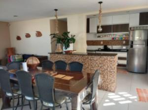 a kitchen with a dining room table and chairs at casa amar guaibim in Guaibim +19 photos
